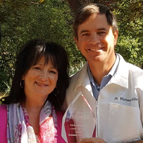 Dr Michael Miller holding Pinnacle award
