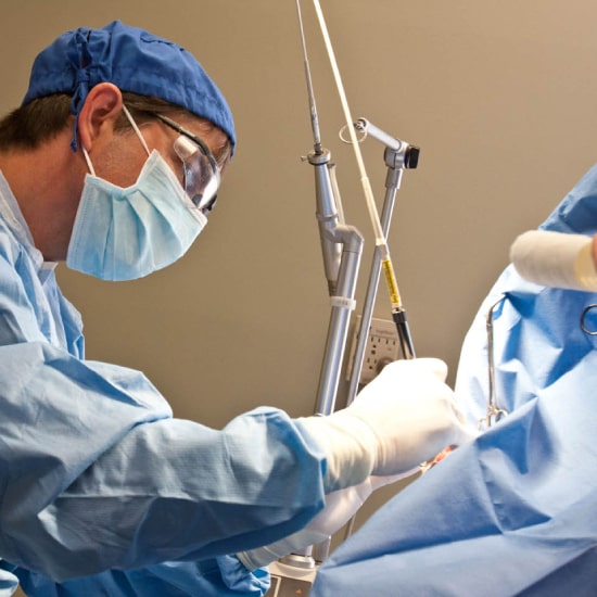 Surgeon performing operation with medical equipment. Surgeon performing operation with medical equipment.
